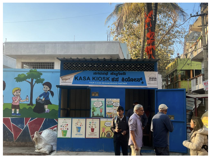 Visitors outside the blue Kasa Kiosk at Hebbagodi