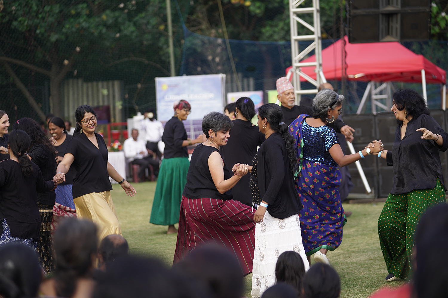 Residents dancing together in a circle at Malhar Mela